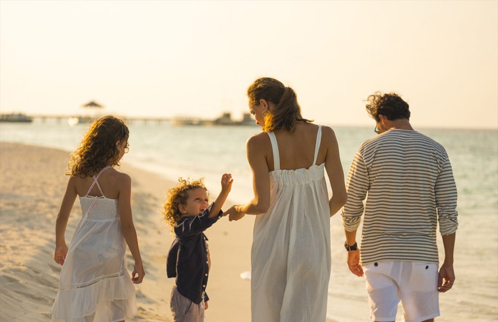 mom and dad with kids on the beach